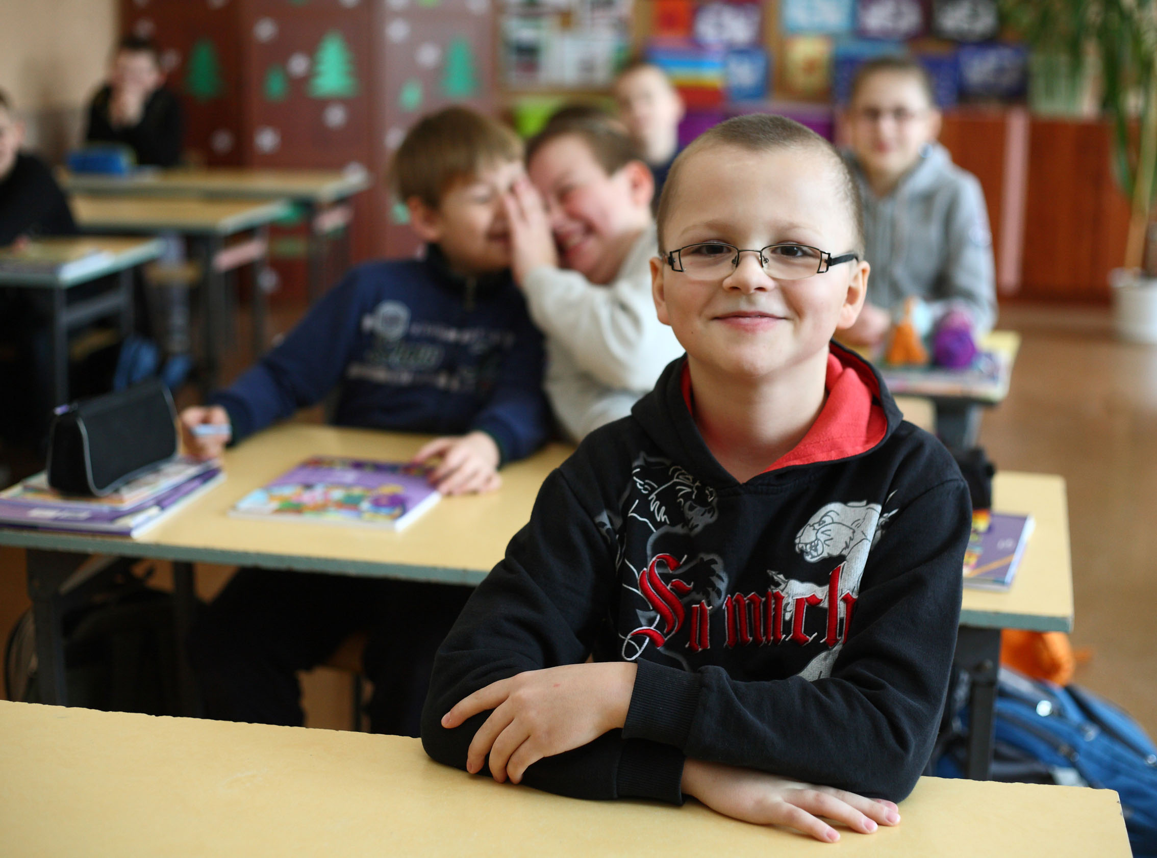 Ein lächender Junge in seinem Klassenzimmer